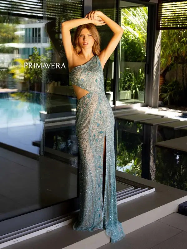 Get ready to make a statement in this Primavera Couture 4135 Long Prom Dress. The fitted silhouette and high slit offer a flattering, sexy look while the one shoulder and side cut outs add a unique touch. Complete with sequin strappy detailing, this formal pageant gown is sure to turn heads.