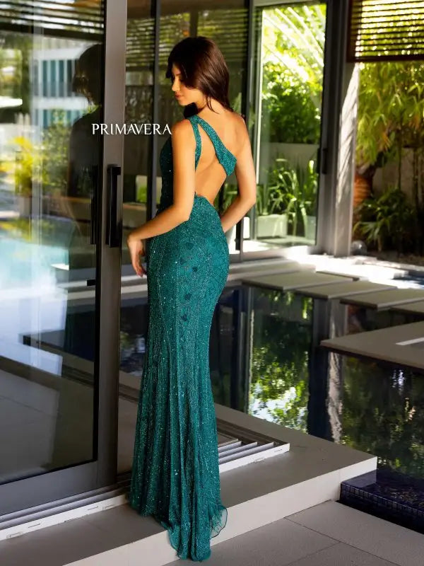 Get ready to make a statement in this Primavera Couture 4135 Long Prom Dress. The fitted silhouette and high slit offer a flattering, sexy look while the one shoulder and side cut outs add a unique touch. Complete with sequin strappy detailing, this formal pageant gown is sure to turn heads.