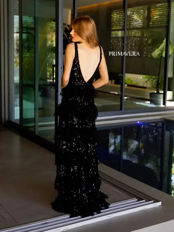 Add a touch of glamour to your special evening with the Primavera Couture 4142 Long Prom Dress. This elegantly sequined gown boasts a fitted silhouette with a high slit and open low back, perfect for showing off your curves. The layered ruffle adds a flirty touch, making it ideal for prom or pageants.