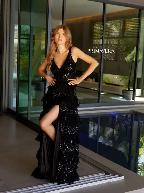 Add a touch of glamour to your special evening with the Primavera Couture 4142 Long Prom Dress. This elegantly sequined gown boasts a fitted silhouette with a high slit and open low back, perfect for showing off your curves. The layered ruffle adds a flirty touch, making it ideal for prom or pageants.