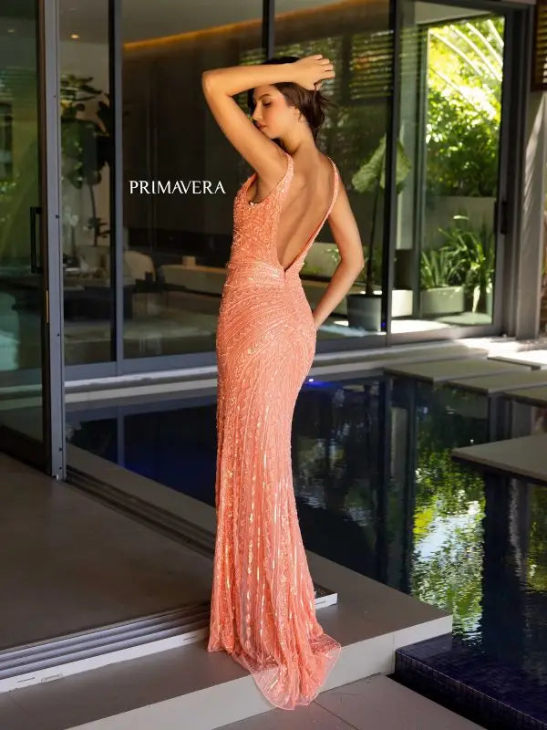 Introducing the Primavera Couture 4143 Long Prom Dress - the perfect choice for your next formal event. Featuring a stunning sequin design, V-neckline, high side slit, and low open back, this dress will make you stand out in any crowd. Elevate your pageant or prom look with this elegant gown.