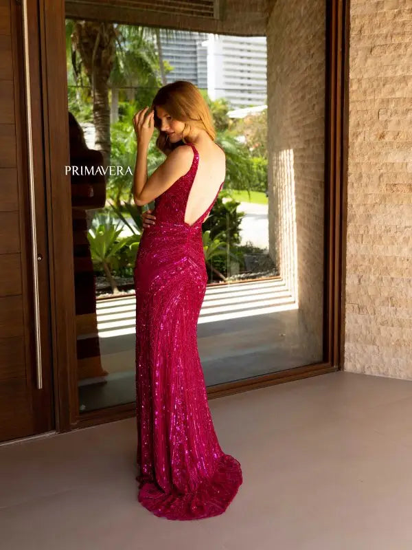 Introducing the Primavera Couture 4143 Long Prom Dress - the perfect choice for your next formal event. Featuring a stunning sequin design, V-neckline, high side slit, and low open back, this dress will make you stand out in any crowd. Elevate your pageant or prom look with this elegant gown.