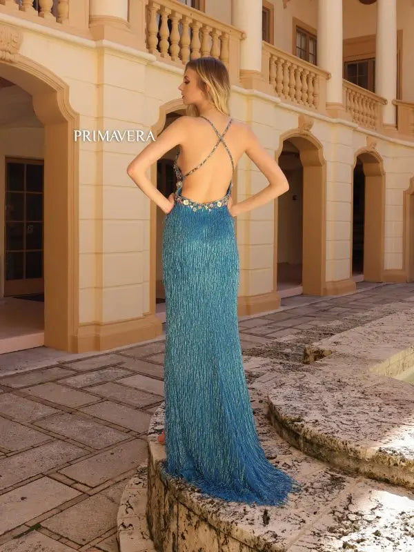 This elegant Primavera Couture 4145 long prom dress features intricate beaded floral detailing on a fitted silhouette, finished with a playful fringe skirt and a high slit. The v-neckline adds a touch of sophistication to this formal pageant gown. Stand out from the crowd in this stunning dress.