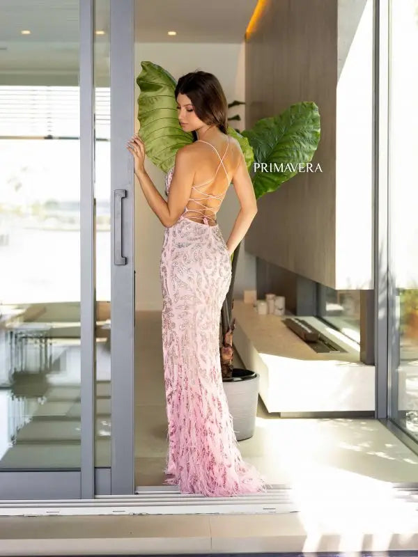 Unleash your inner goddess in the stunning Primavera Couture 4147 Long Prom Dress. This form-fitting gown features a lace-up back, shimmering sequins, and delicate feathers for a touch of glamour. The scoop neck and high slit add a touch of sophistication to this elegant formal pageant gown.