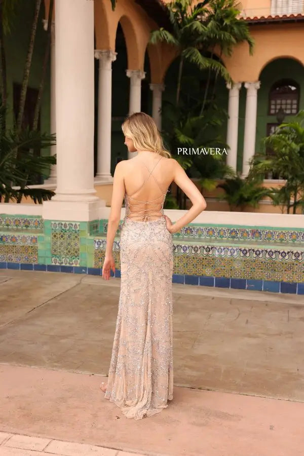 This Primavera Couture 4162 long prom dress is a perfect choice for any formal occasion. Featuring a fitted silhouette with a high slit, this stunning gown is adorned with sequin and bead detailing on delicate lace. The open back adds a touch of elegance, making it ideal for pageants and formal events.
