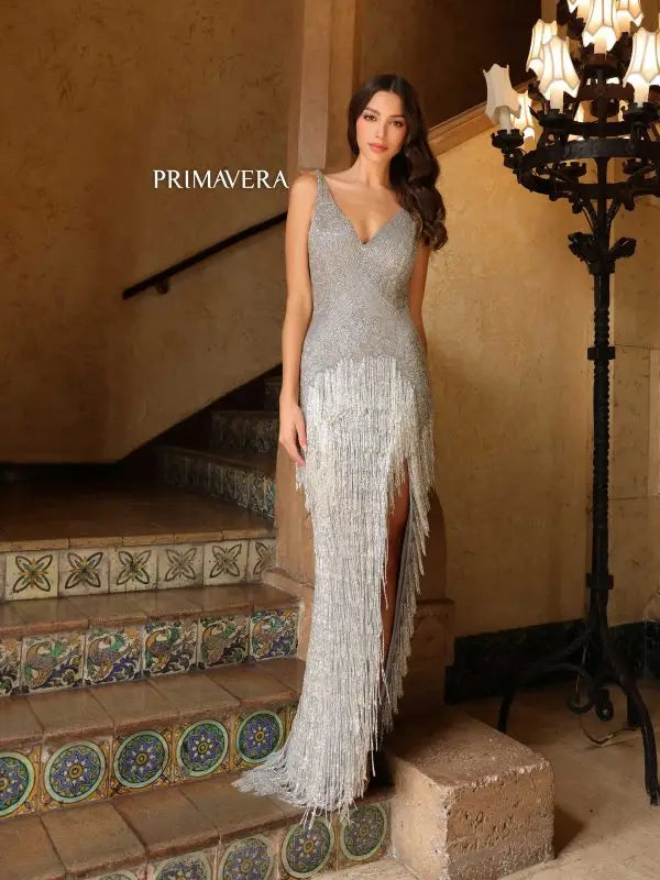 This Primavera Couture 4165 Long Prom Dress features fringes, a fitted design, a high slit, a V neck, an open back, and a formal pageant gown style. Make a bold and fashionable statement at your next formal event with this stunning dress. With its unique features, you'll feel confident and stylish all night long.