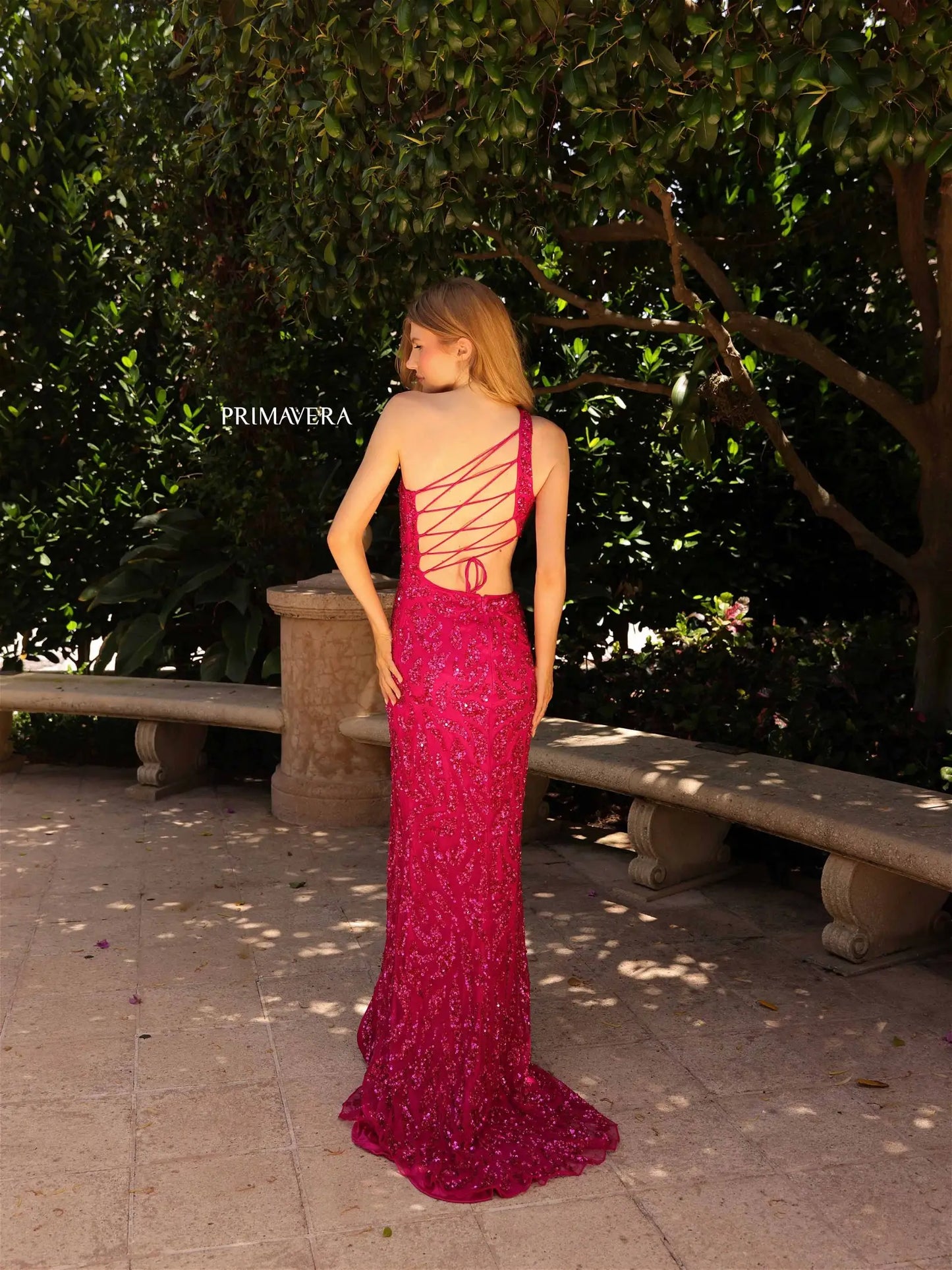 The Primavera Couture 4191 prom dress is a dazzling statement piece. Crafted from sequins and beading, its fitted body, asymmetrical neckline, and side-cutouts flatter any figure. The backless style features an open back with corset lacing, and a high side slit to make a grand entrance. Perfect for special occasions.  Sizes: 000-24  Colors: Gold, Fuchsia, Sage Green, Crystal Blue