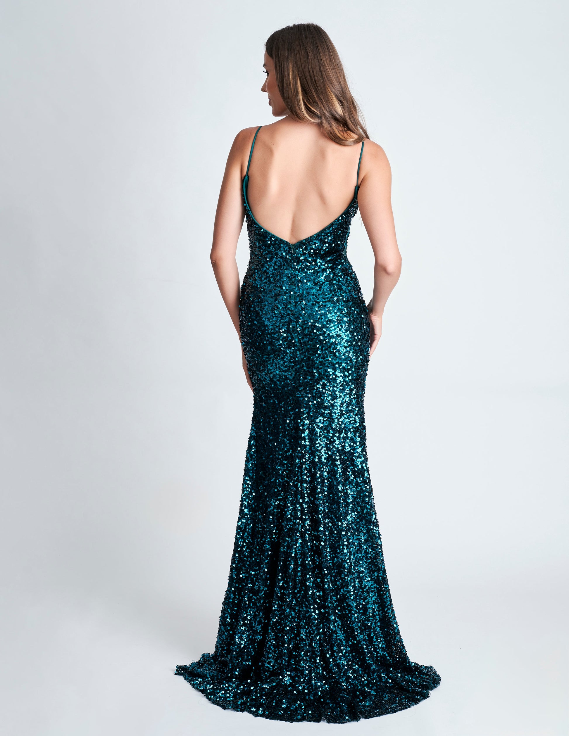 This fitted sequin long prom dress by Nina Canacci 4410 is designed to make you stand out on the dance floor. With a low back and V neck, this elegant gown features a stylish slit that will add an extra touch of sophistication to your look. Perfect for any formal occasion, this dress is sure to make you feel confident and glamorous.