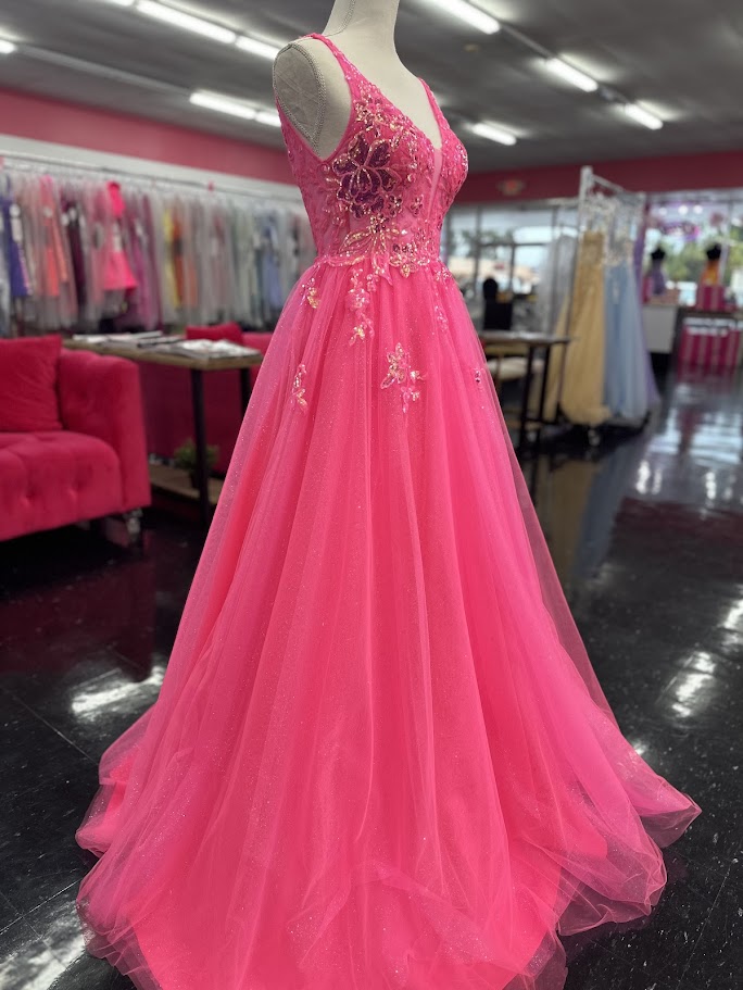 This Nina Canacci 4427 ballgown in size 4 showcases exquisite sequin lace detailing over a sheer bodice, creating a refined and elegant look. The flattering V-neckline and classic A-line silhouette enhance your figure while offering graceful movement. Perfect for prom or formal events, this gown combines timeless sophistication with subtle sparkle for a memorable evening.

Size: 4

Color: Fuchsia