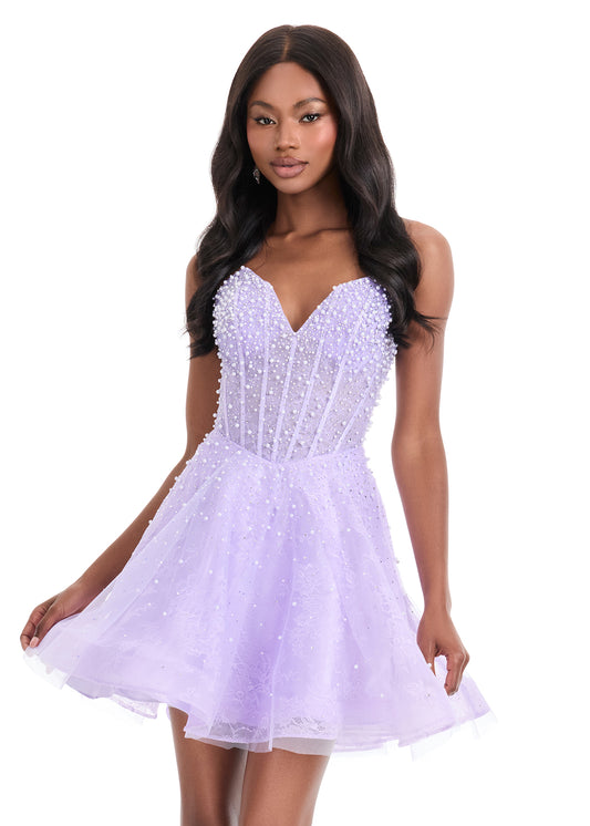 The Ashley Lauren 4924 Short Lace Cocktail Dress combines delicate lace with a sheer corset bodice, adorned with intricate beadwork for subtle elegance. Its fit-and-flare silhouette flatters the figure while providing comfortable movement, making it an excellent choice for formal events or homecoming. This dress balances classic design with modern detailing to create a sophisticated and stylish look. Feel elegant in the ASHLEYlauren Style 4924, a lace dress featuring intricate press-on beading throughout th