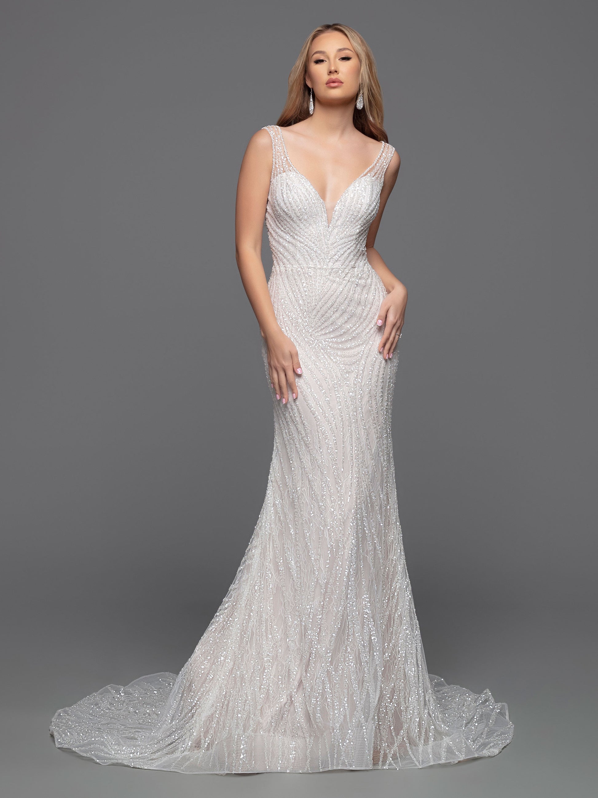 The Davinci Bridal 50800 wedding dress is the perfect combination of modern and classic style. Its fitted silhouette and V-neckline highlight a bride's shape while the geometric beading brings a touch of sparkle and glamour. The sheer straps and chapel train add a hint of allure. Ideal for a chic and sophisticated wedding.  Sizes: 2-20  Colors: Ivory/Ivory, Ivory/Nude
