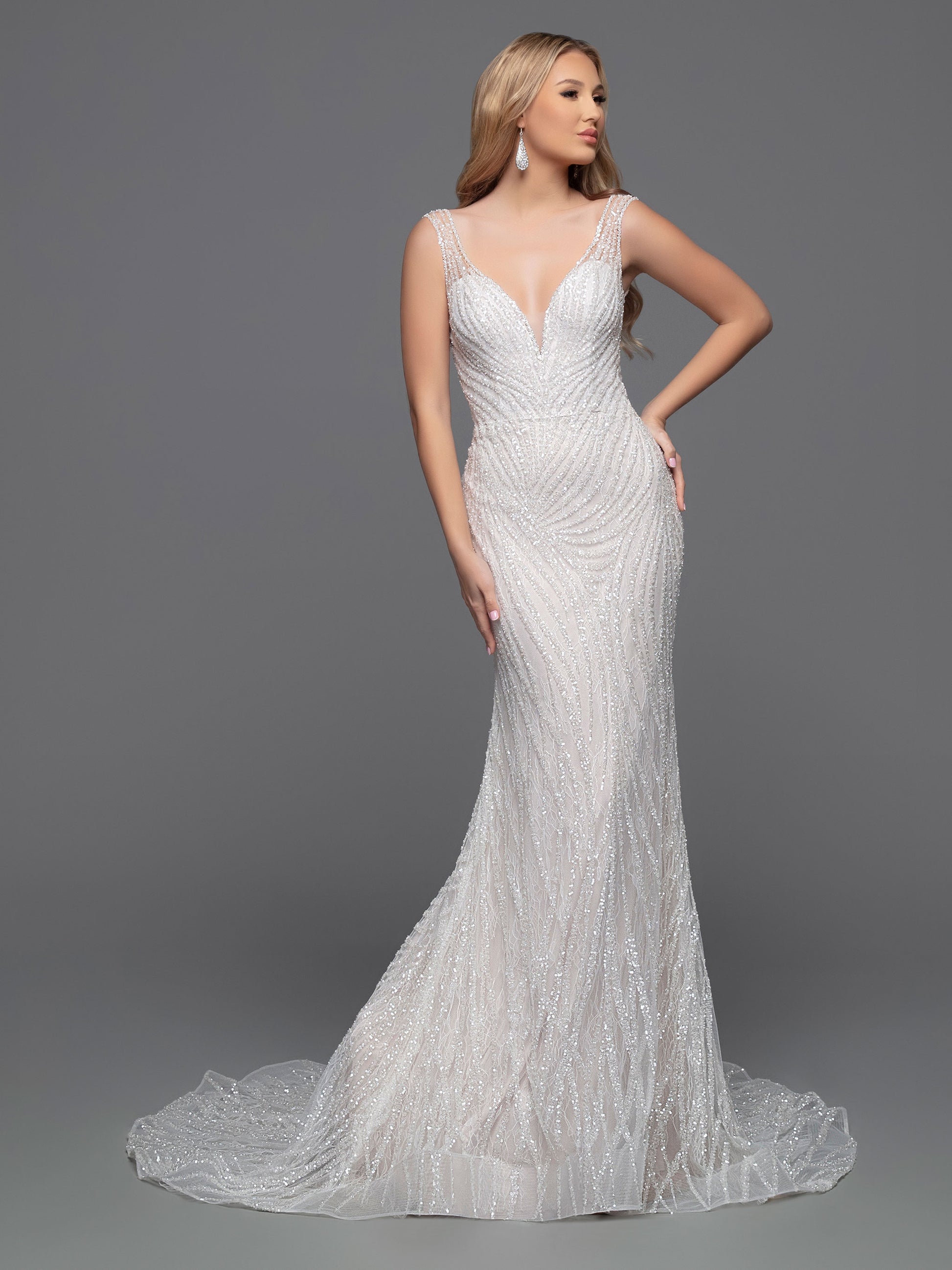 The Davinci Bridal 50800 wedding dress is the perfect combination of modern and classic style. Its fitted silhouette and V-neckline highlight a bride's shape while the geometric beading brings a touch of sparkle and glamour. The sheer straps and chapel train add a hint of allure. Ideal for a chic and sophisticated wedding.  Sizes: 2-20  Colors: Ivory/Ivory, Ivory/Nude