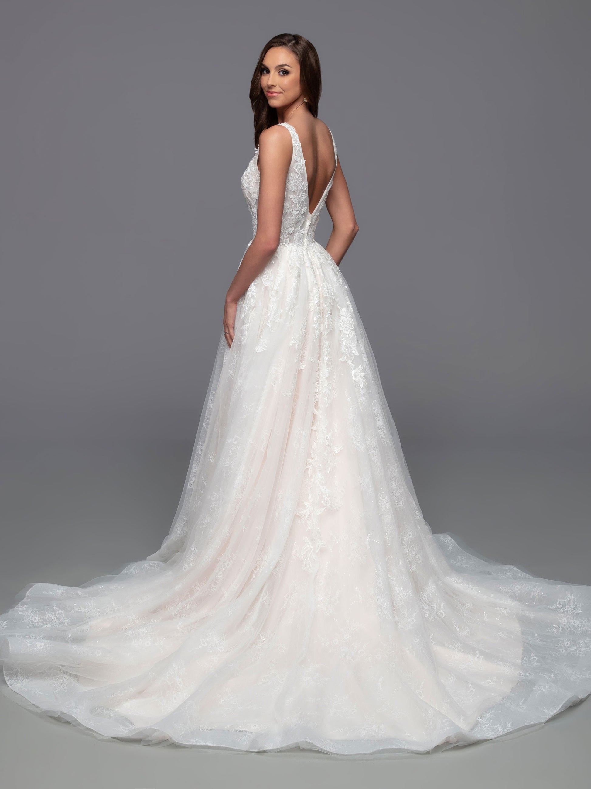 The Davinci Bridal 50821 is a stunning choice for a wedding dress, featuring a fitted V-neckline, sheer bodice, and a gorgeous a-line maxi skirt with a chapel length train and delicate sequin detailing. The daring slit skirt adds a daring touch for a timeless yet modern look.  Sizes: 2-20  Colors: Ivory/Ivory, Ivory/Light Blush