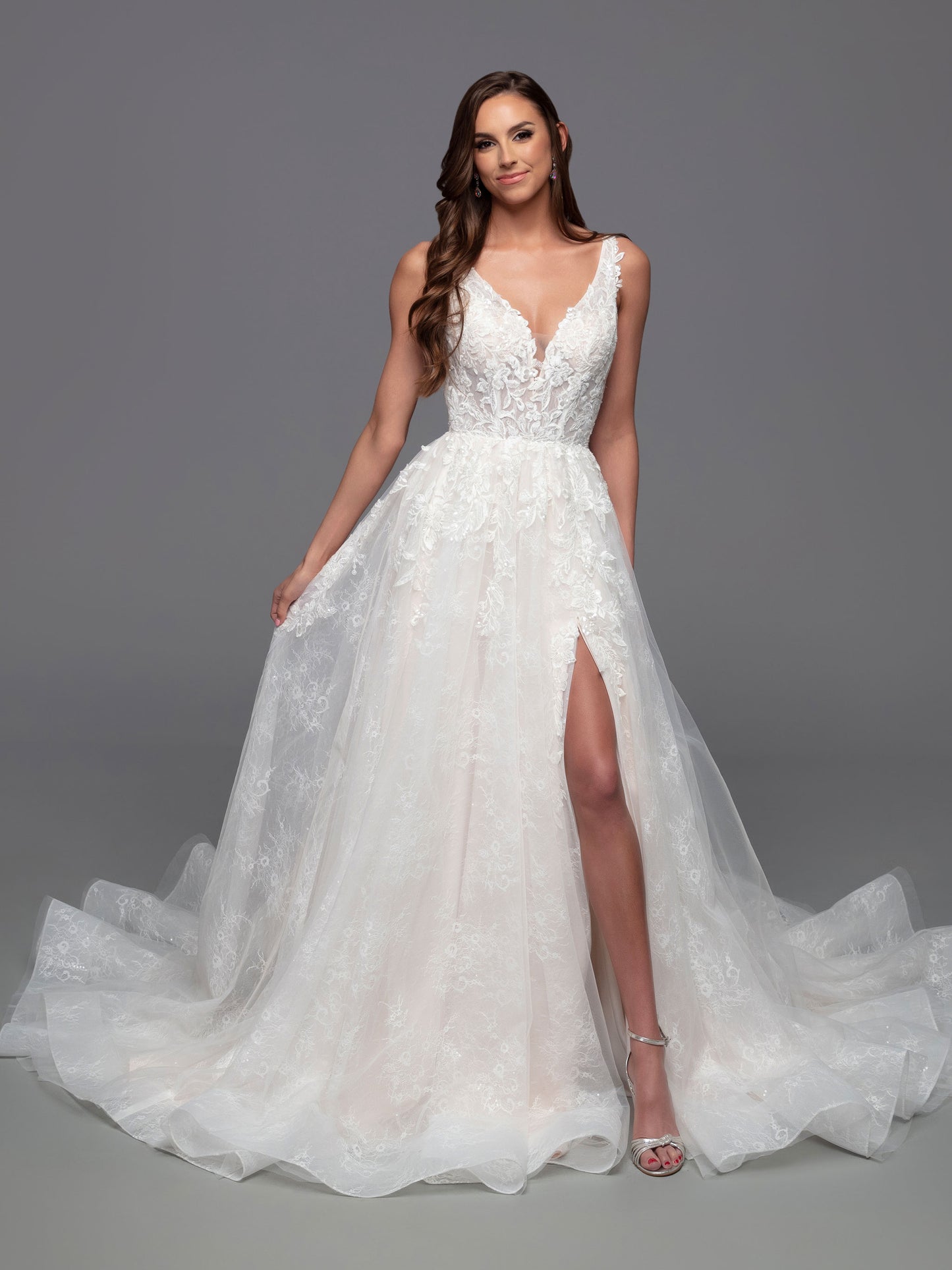 The Davinci Bridal 50821 is a stunning choice for a wedding dress, featuring a fitted V-neckline, sheer bodice, and a gorgeous a-line maxi skirt with a chapel length train and delicate sequin detailing. The daring slit skirt adds a daring touch for a timeless yet modern look.  Sizes: 2-20  Colors: Ivory/Ivory, Ivory/Light Blush