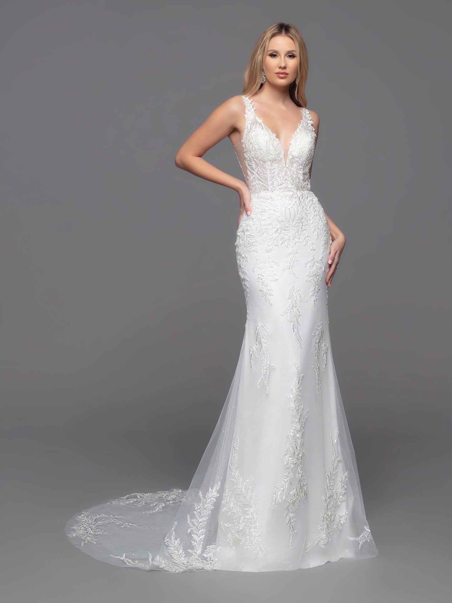 This Davinci Bridal 50822 wedding dress offers an alluring mix of modern elegance and classic sophistication. The sheer lace bodice is perfectly complemented by the beaded sequin and lace applique accents on the floor-length skirt lining and sheer chapel train. The deep V-neck & back and sheer side panels flatter any figure. Make an unforgettable statement on your special day.  Sizes: 2-20  Colors: Ivory