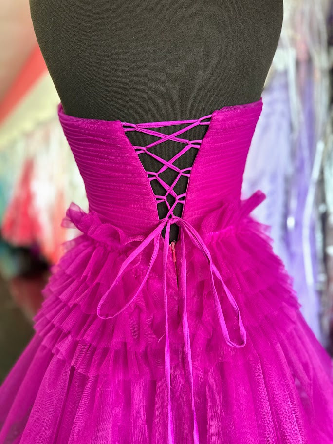 Elevate your evening with the Nina Canacci 5305 prom dress, featuring a flowing A-line silhouette crafted from layered magenta tulle. The long pleated skirt adds graceful movement, while the corset bodice offers a flattering fit and elegant structure. A daring maxi slit enhances allure, making this ballgown perfect for making a sophisticated statement at any formal event.

Size: 4

Color: Magenta