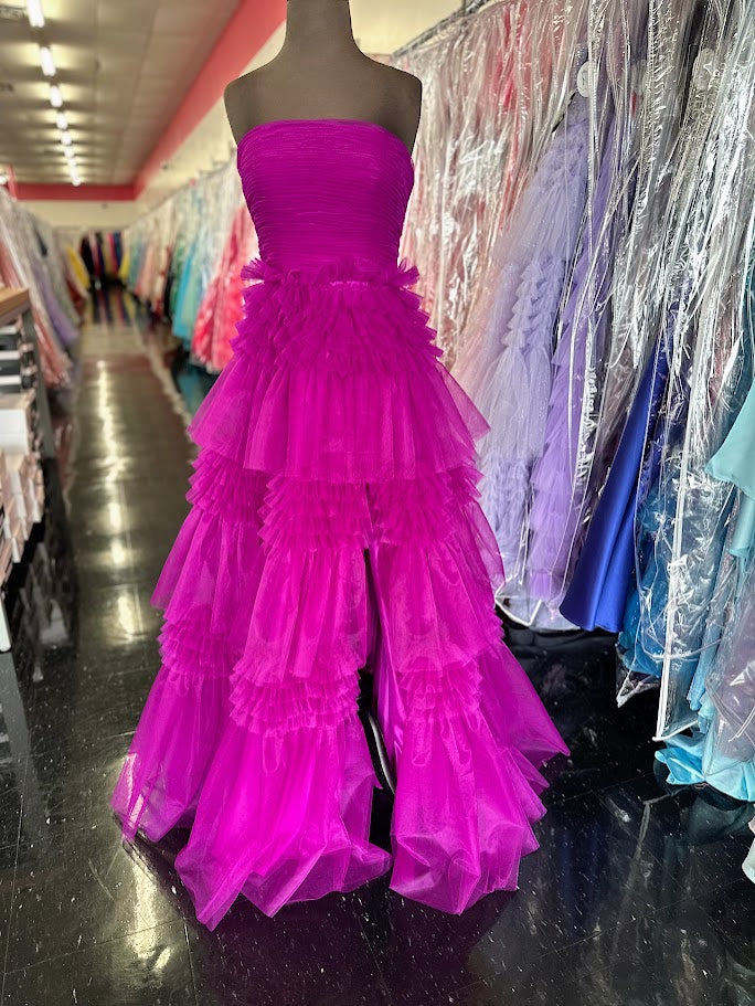 Elevate your evening with the Nina Canacci 5305 prom dress, featuring a flowing A-line silhouette crafted from layered magenta tulle. The long pleated skirt adds graceful movement, while the corset bodice offers a flattering fit and elegant structure. A daring maxi slit enhances allure, making this ballgown perfect for making a sophisticated statement at any formal event.

Size: 4

Color: Magenta