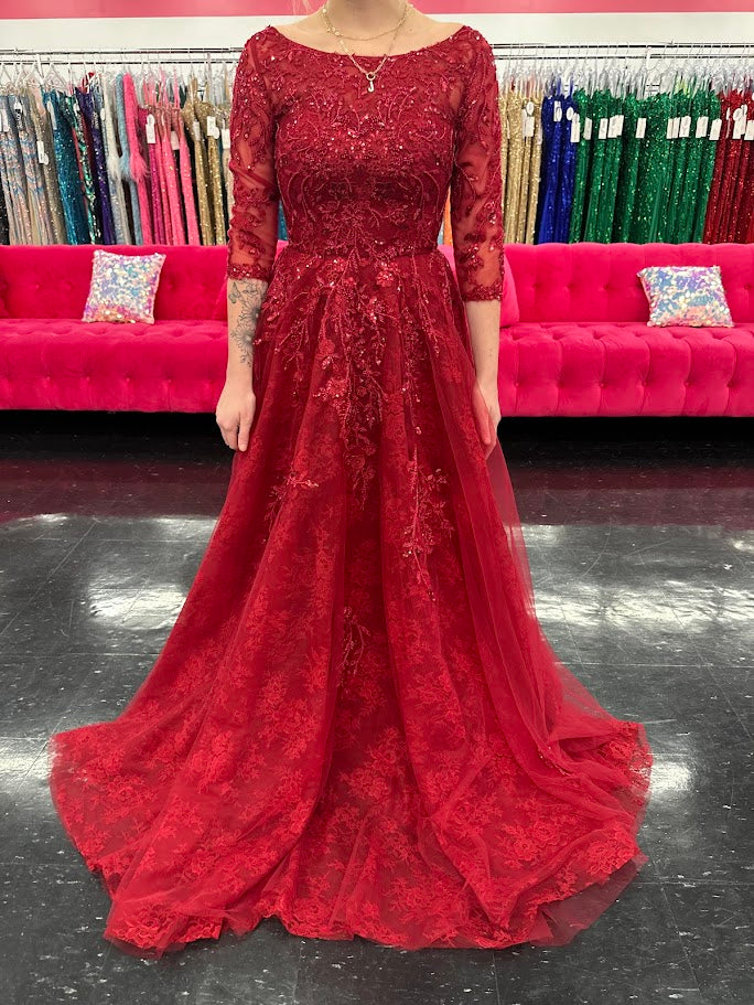 This Nina Canacci 5311 gown in size 4 features a rich lace fabric crafted into a flattering A-line silhouette. The high neckline and formal sleeves offer a polished, elegant look, while delicate beading and sequins add a subtle shimmer perfect for evening events. Ideal for mother-of-the-bride or other formal occasions, this dress combines timeless sophistication with exquisite detailing.

Size: 4

Color: Burgundy