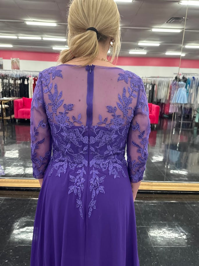 Elevate your formal occasion with the Nina Canacci 5312 gown, featuring delicate lace and chiffon fabric that gracefully drapes for a refined silhouette. The long sheer sleeves and high neckline offer elegant coverage, while crystal embellishments add a subtle sparkle, perfect for a mother of the bride or wedding guest seeking timeless sophistication.

Size: 4

Color: Purple