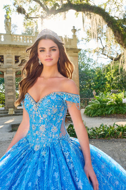 Be the belle of the ball in the Amarra 54220 Quinceanera Ball Gown. This stunning formal dress features a sheer crystal lace train and fringe, for a unique and eye-catching look. The off the shoulder design adds a touch of elegance and the perfect amount of skin. Stand out in style. Unleash your inner princess with our enchanting lace ball gown! Crafted with a dreamy lace fabric adorned with detailed floral pattern