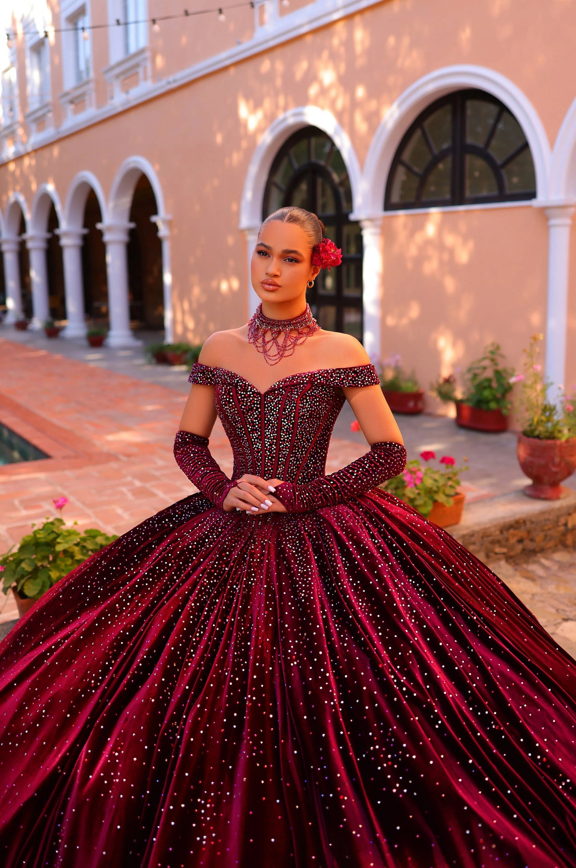 Elevate your quinceanera style with the luxurious Amarra 54257 dress. Made of velvet and adorned with crystal accents, it features a ball gown silhouette with an off-the-shoulder neckline. Complete the look with the included corset necklace and velvet gloves. A perfect choice for a night to remember.