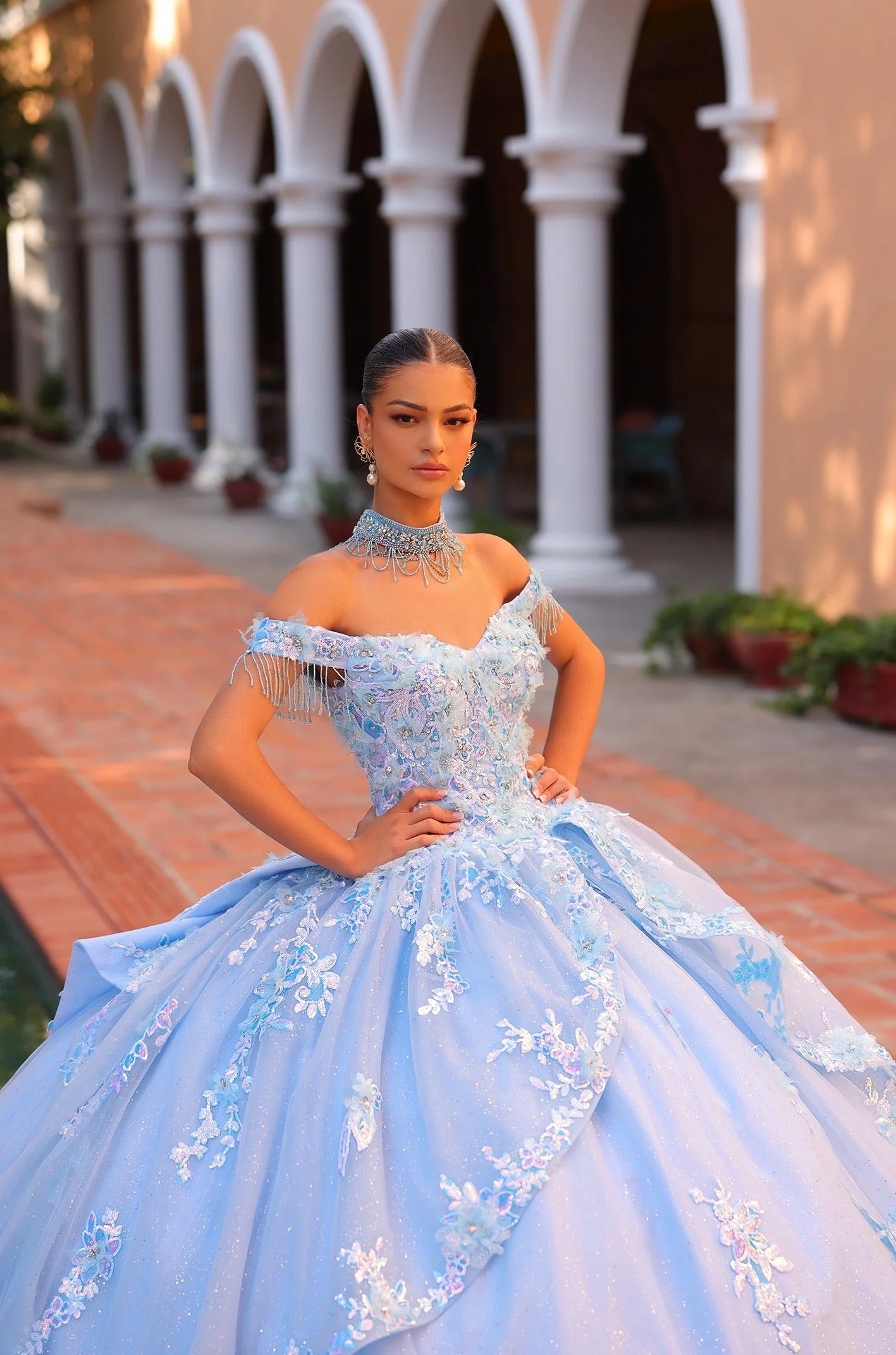 Effortlessly radiant and elegant, the Amarra 54305 quinceanera dress showcases a shimmering ballgown design with an off the shoulder fringe cape and intricately beaded sequin details. The layered lace skirt adds a touch of glamour to this stunning dress, ensuring you will stand out at any special occasion. Cinderella