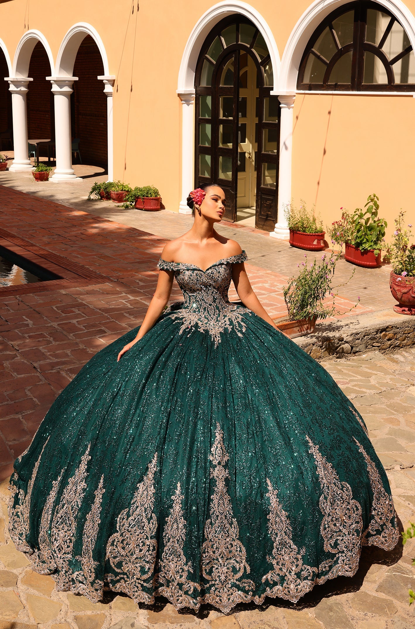 This Amarra 54324 Quinceanera Dress boasts a glittering hooded cape and off-the-shoulder corset, perfect for making a grand entrance at any party or ball. The exquisite train and bow detail add an extra touch of elegance to this stunning gown. Elevate your style with this eye-catching dress.