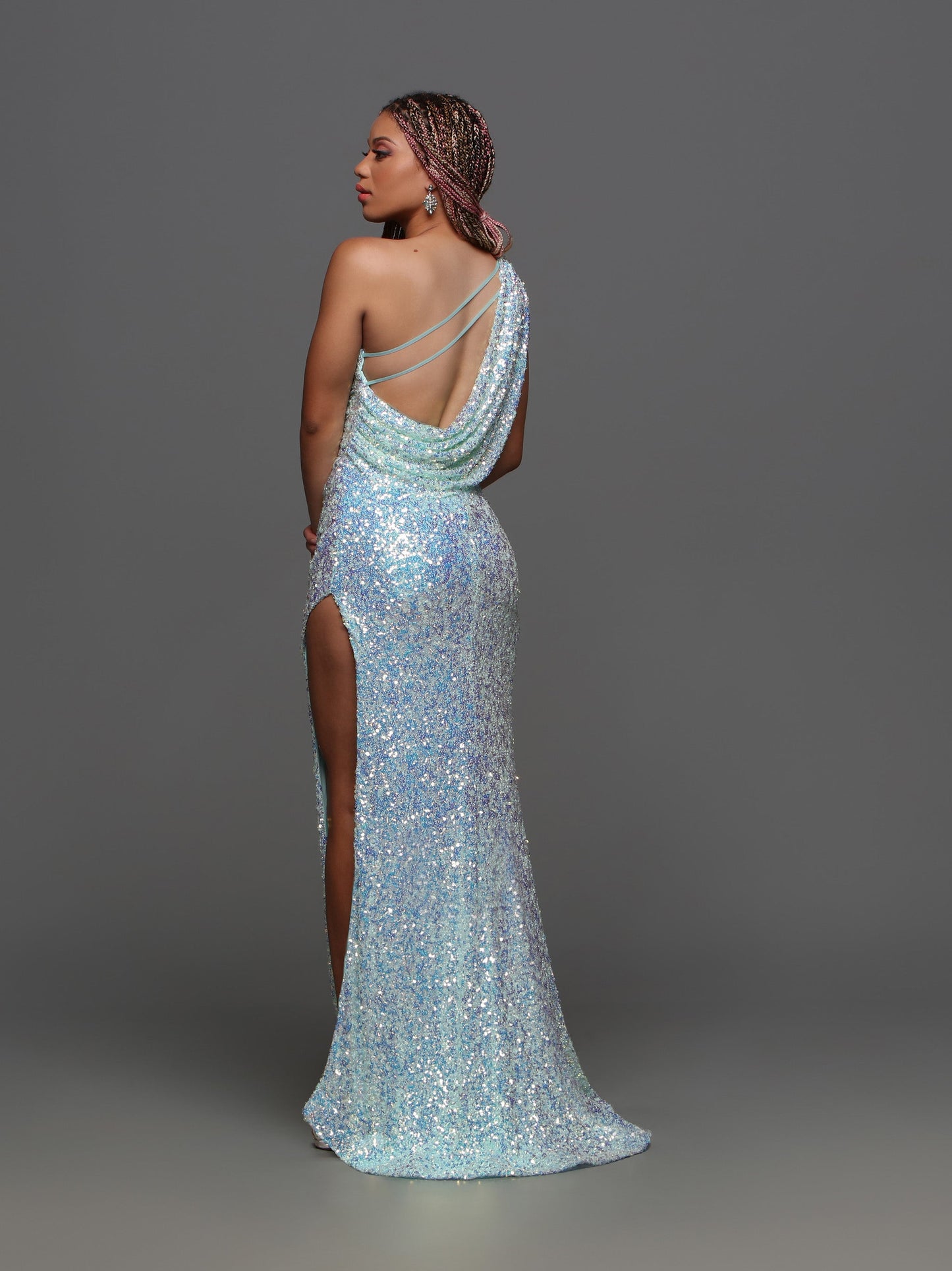 The Candice Wang 72346 prom dress boasts stunning sequins, a one shoulder design, and a high slit for an elegant and alluring look. With a draped open back, this formal gown exudes sophistication and glamour. Step out in style and turn heads at your next special occasion.  Sizes: 4-12  Colors: Aqua