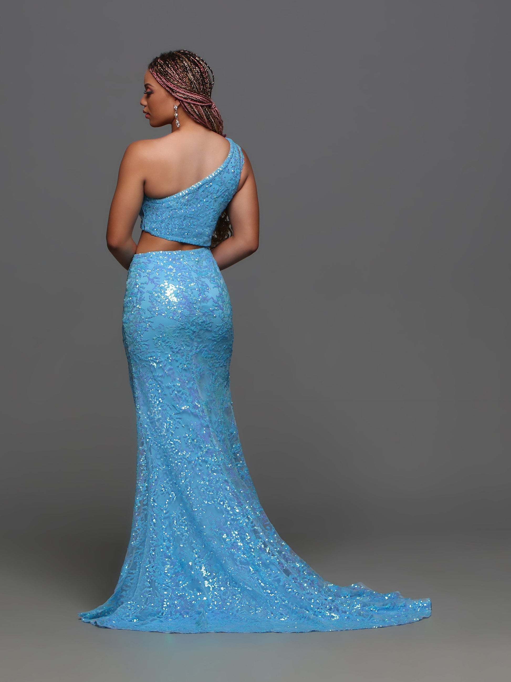 Dazzle the crowd in the Candice Wang 72389 Prom Dress. Featuring an alluring one shoulder design with intricate sequin cutouts, this gown exudes elegance and glamour. The thigh-high slit and train add a touch of drama to this formal dress. Perfect for standing out at prom or any special occasion.  Sizes:: 0-20  Colors: Blue
