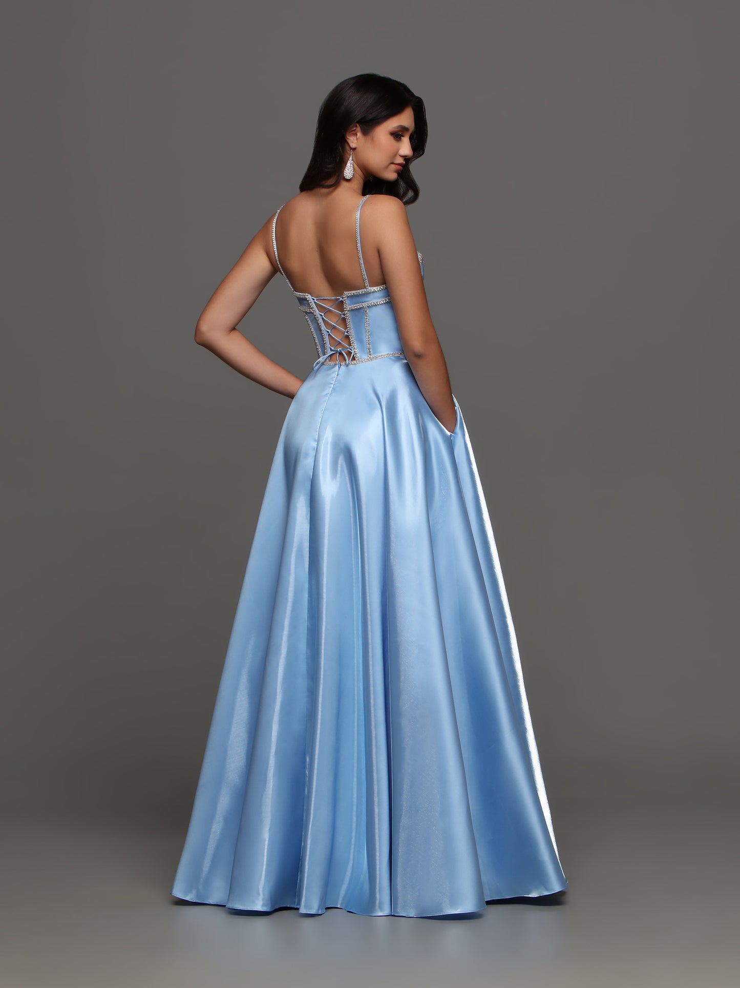 Experience elegance and glamour with the Candice Wang 72398 A Line Satin Maxi Slit Ballgown. The corset top features intricate crystal detailing, while the flowing satin skirt boasts a thigh-high slit. This dress is perfect for prom, formal events, or any special occasion. Add a touch of luxury to your wardrobe. Pockets  Sizes: 0-16  Colors: Light Blue, Red