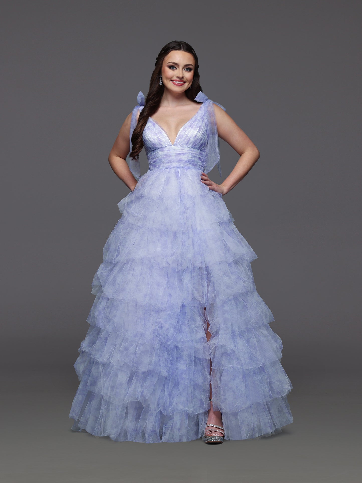 Step into elegance with the Candice Wang 72472 ballgown, designed in a delicate lavender and ivory palette. This size 2 dress features layered ruffles and a charming bow print that add a whimsical touch to your formal look. The flowing silhouette and tasteful slit offer both grace and comfort, making it perfect for prom or any special occasion where you want to stand out beautifully.

Size: 2

Color: Lavender/Ivory