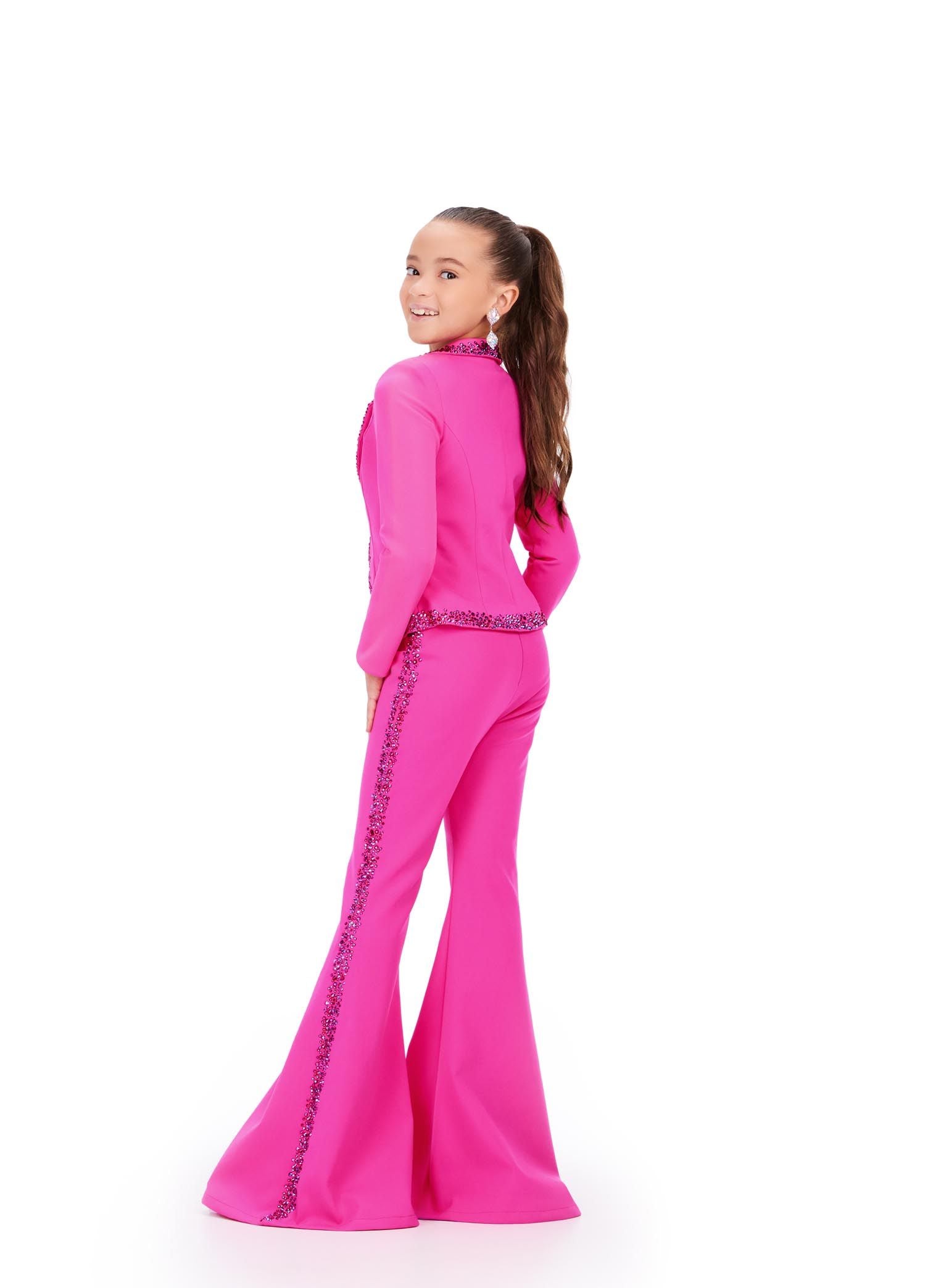 The Ashley Lauren Kids 8209 Two Piece Jumpsuit Suit features bell-bottom trousers and a crystal-studded jacket for a fashionable pageant look. High-quality materials ensure long-lasting comfort and style. Strike a pose in this fun and fabulous two piece set! Made from scuba, this suit has press on stones that trim the jacket and pant legs.  Two Piece Press On Stone Trim Flare Pant Legs Jumpsuit Sizes: 2-16 Colors: Black, Fuchsia, Royal Blue