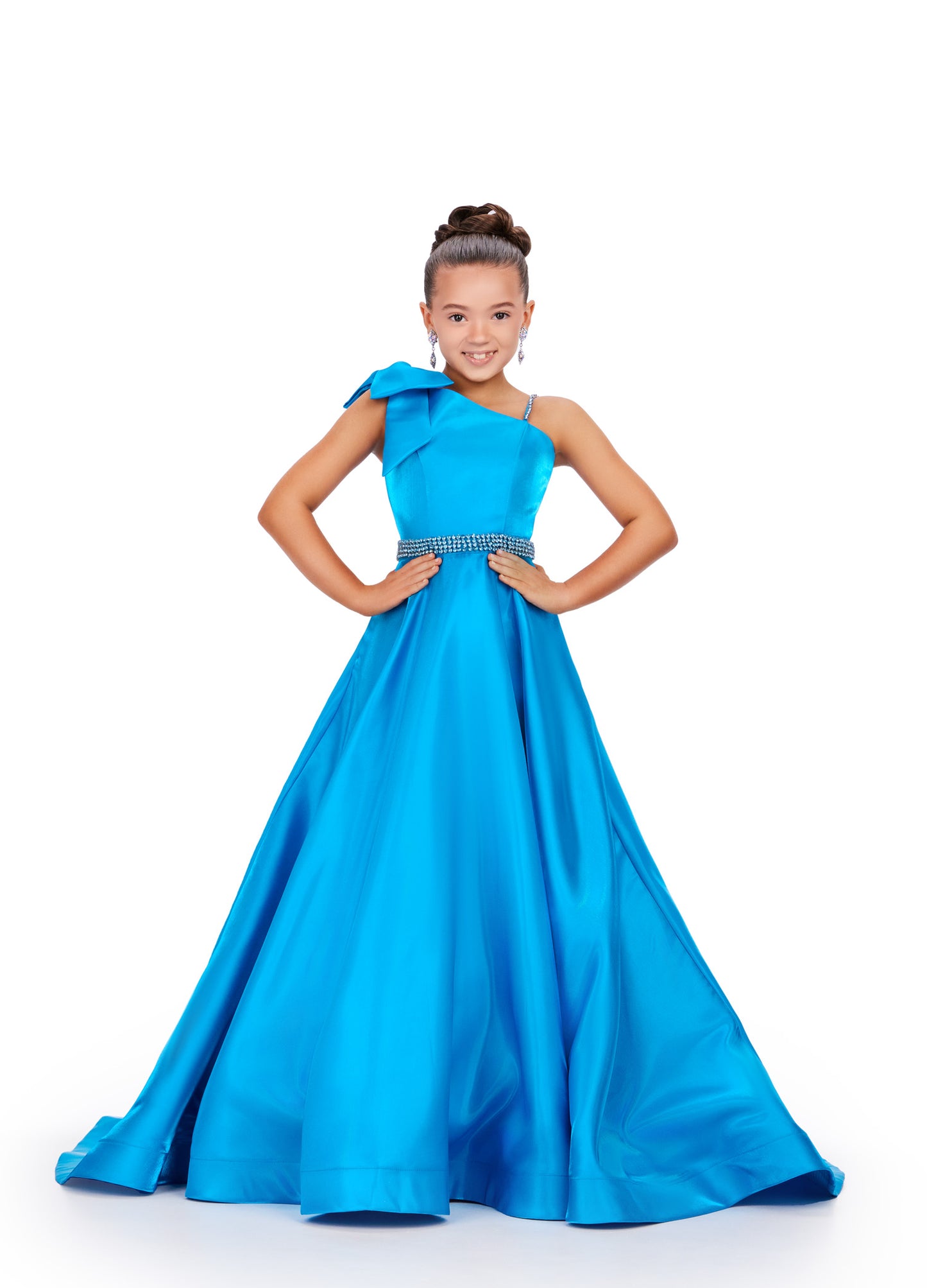 Expertly crafted for the pageant stage, the Ashley Lauren Kids 8248 dress is designed with a shimmering satin fabric and a unique one-shoulder bow for a touch of elegance. Its A-line silhouette flatters any figure while making a stunning statement. Perfect for a winning performance. This beautiful satin gown features a one shoulder neckline with bow. The look is complete with a rhinestone belt and full skirt.