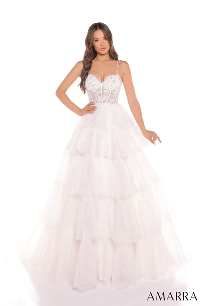 Experience luxury and elegance in the Amarra 88345 Ballgown. This stunning dress features sheer beaded corset detailing and layers of flowing fabric, creating a show-stopping look. Perfect for prom, pageants, or any formal event, this dress will make you feel like royalty.

Sizes: 000-16

Colors: Hot Pink,&nbsp;Ivory,&nbsp;Light Blue,&nbsp;Periwinkle,&nbsp;Red