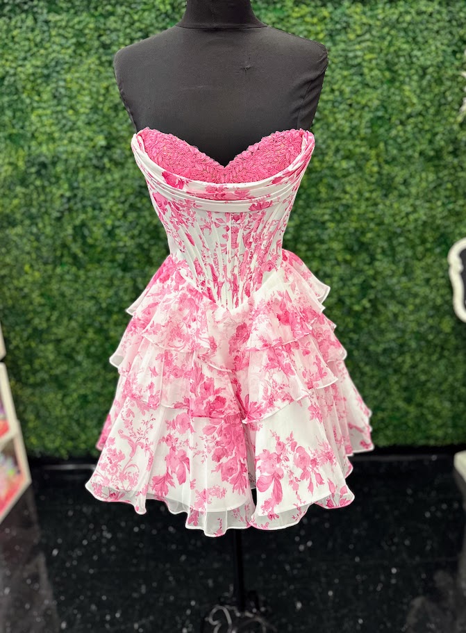Elevate your evening with the Amarra 89050, a short print corset dress designed to flatter every curve. Featuring delicate lace detailing and a sophisticated scoop neckline, this flared homecoming gown combines elegance with modern charm. Perfect for cocktail events or formal occasions, its tailored fit and graceful silhouette ensure you stand out with timeless style. Feel effortlessly chic in this floral print mini dress with a tiered ruffle skirt that brings graceful motion to every step. The structured c