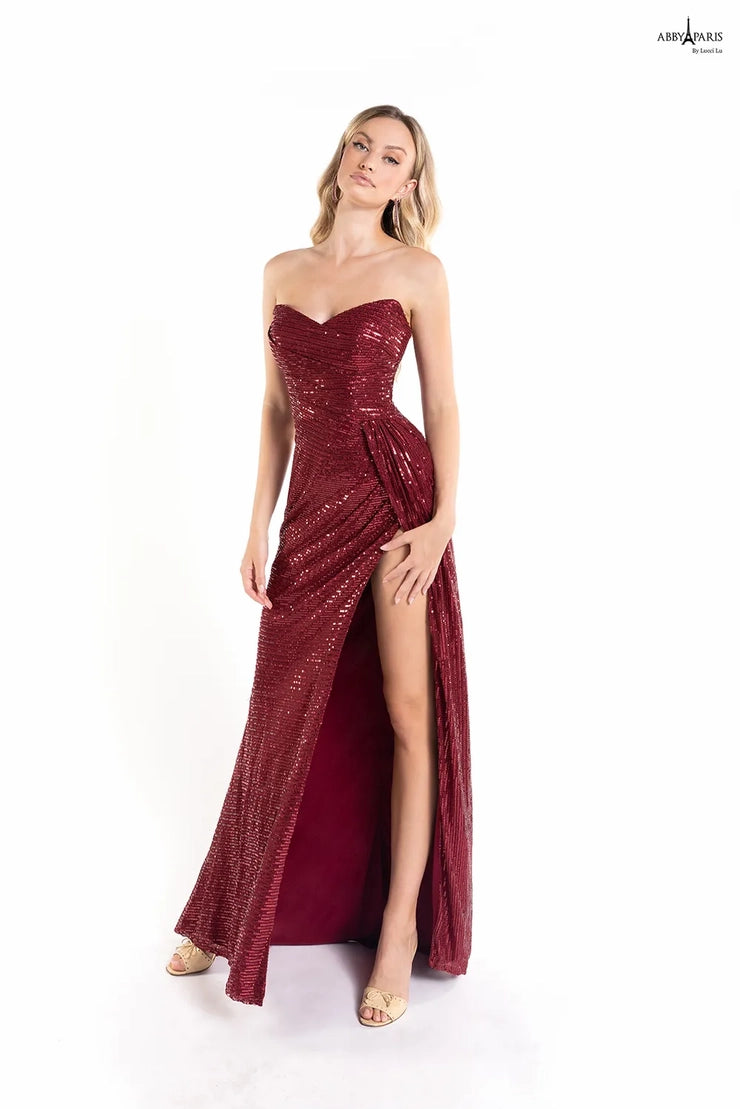 Look dazzling in Abby Paris' 90160 prom dress. This fit and flare style flatters the figure and features a sweetheart neckline and sequin embellishment. The slit and long hemline make this dress perfect for your next special event.