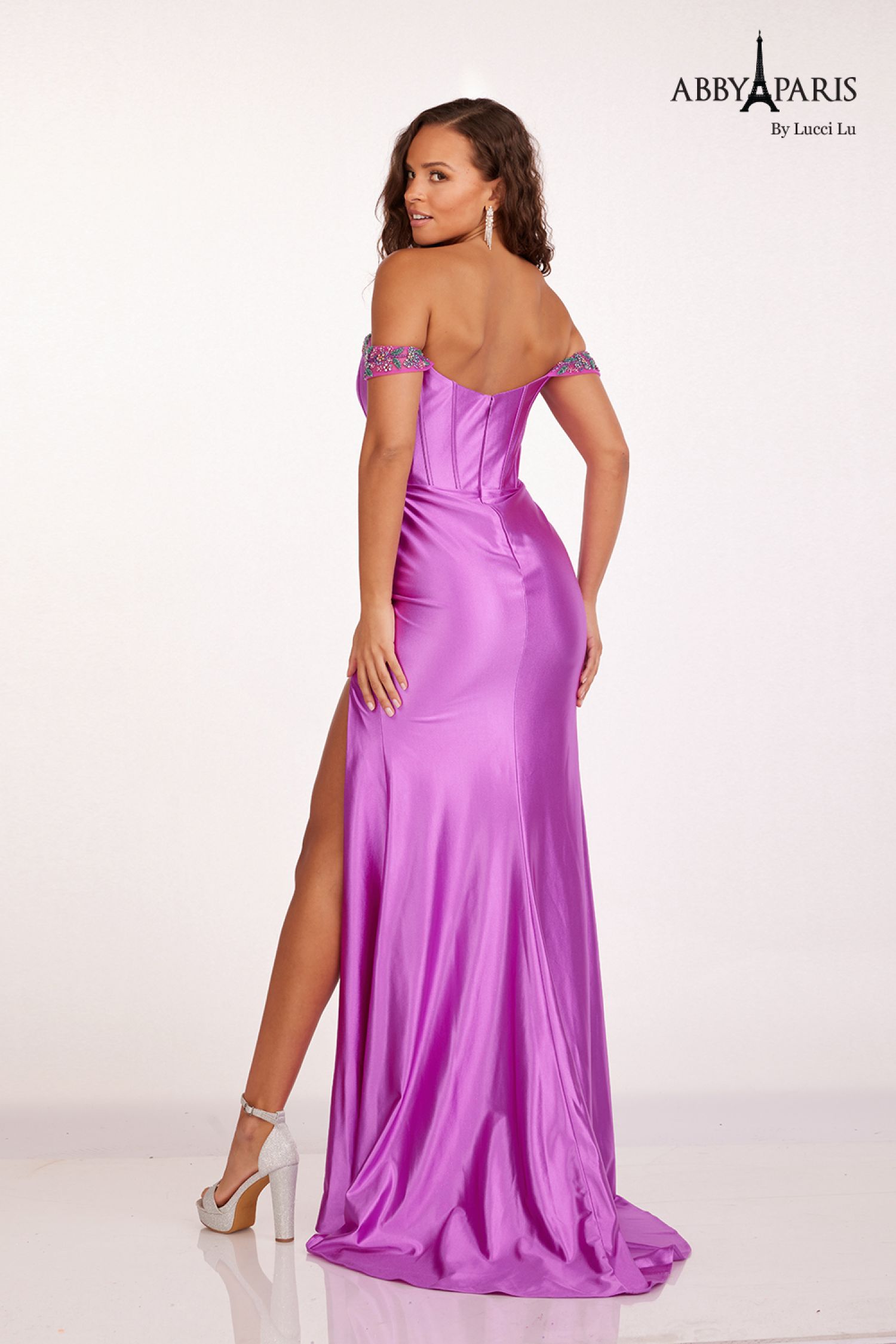 Discover the perfect blend of elegance and style with our Abby Paris 90206 Prom Dress. Crafted with luxurious satin and intricate beading, this dress is designed to accentuate your figure and make you stand out at any formal event. The stunning off-the-shoulder neckline and corset back add a touch of sophistication, while the maxi slit adds a modern twist. Embrace your inner fashion icon with this statement piece.  Sizes: 0-16  Colors: Emerald, Red, Violet