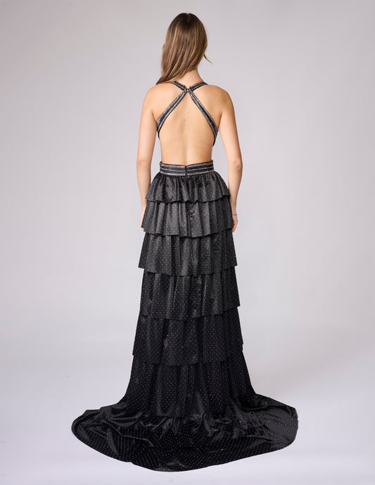 Nina Canacci's 9200 is a show-stopping pageant gown that combines elegance with contemporary flair. The crystal-layered jersey skirt features intricate micro crystal embellishments that catch light beautifully, while strategic side cutouts add modern sophistication. A dramatic maxi slit and flowing train create movement and grandeur, making this dress ideal for prom, pageants, and formal competitions. The jersey construction ensures comfortable wear throughout the evening while maintaining a polished silhou