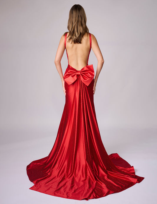 Make a stunning entrance in this Nina Canacci 9212 prom gown, expertly crafted from luxurious crystal-studded jersey. The backless silhouette showcases elegant lines while the detachable oversized bow adds dramatic flair. A removable overskirt transforms the mermaid base into a sophisticated formal statement piece. Perfect for prom, pageants, or black-tie events, this gown combines timeless elegance with contemporary design details that command attention.

Sizes: 0-14

Colors: Sky Blue, Red, Black