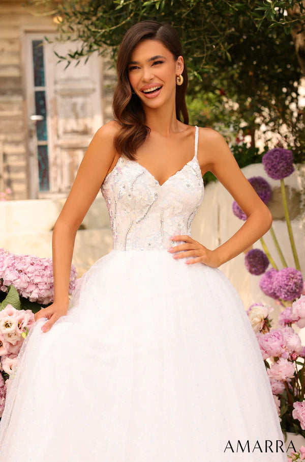 This Amarra 94020 spectacular tulle prom gown with a sweetheart neckline and beaded crystals will have you feeling like a princess for the night. Its color - white - is dazzling, and sparkles even more in the light of the beaded crystals that decorates the shimmering tulle skirt. Above the skirt, is the beautiful bodice designed delicately with sequins with sparse coloring of light blue, yellow and brown. 