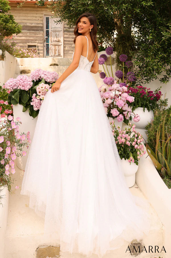 This Amarra 94020 spectacular tulle prom gown with a sweetheart neckline and beaded crystals will have you feeling like a princess for the night. Its color - white - is dazzling, and sparkles even more in the light of the beaded crystals that decorates the shimmering tulle skirt. Above the skirt, is the beautiful bodice designed delicately with sequins with sparse coloring of light blue, yellow and brown. 