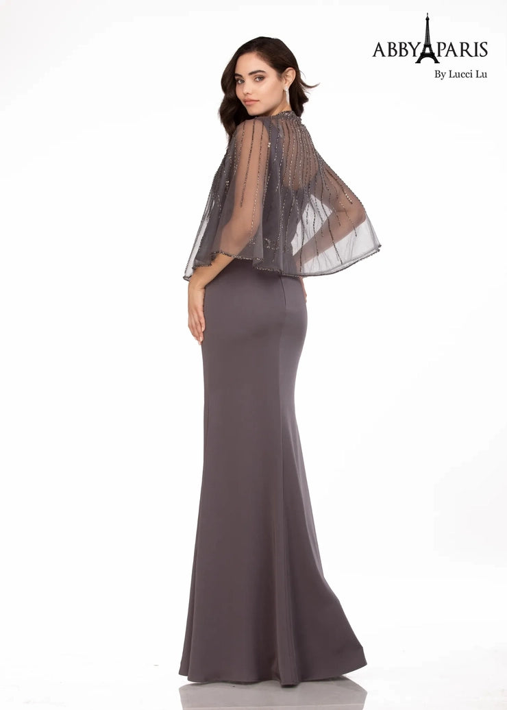 Abby Paris 96062W A-Line Detachable Short Drape Cape Embellished Belt Plus Size MOB Formal Gown. This Abby Paris 96062W A-Line Formal Gown is a stunning and sophisticated choice for the modern woman. Its A-line silhouette flatters and highlights your curves, while the detachable short drape cape adds a chic and unique twist to a timeless style. The embellished belt adds a bit of sparkle to complete the look.