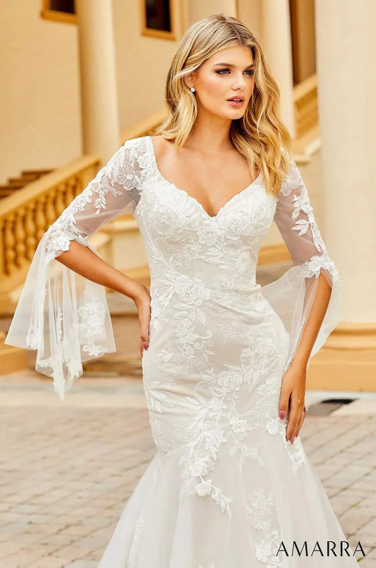 Amarra Bridal 84386 "Anna" Mermaid V-Neck Sheer Floral Long Sleeve Train Wedding Dress. If you’re looking for a wedding gown that shows some skin, but not too much, meet Anna. This captivating gown features a deep-v neckline and sheer sleeves that cover the arms, but still dare to show a little skin