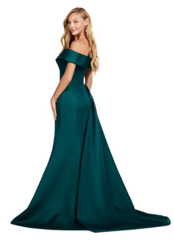 This Ashley Lauren 11425 Long Evening Dress is the perfect choice for any formal occasion. The off-shoulder design adds a touch of elegance, while the fitted satin fabric hugs your figure for a flattering silhouette. The overskirt adds a dramatic flare, making you feel like a pageant queen. Elevate your style with this versatile and stunning dress. An elegant off the shoulder neckline drapes the shoulders in elegant evening gown. The look is complete with beaded details and a side overskirt.