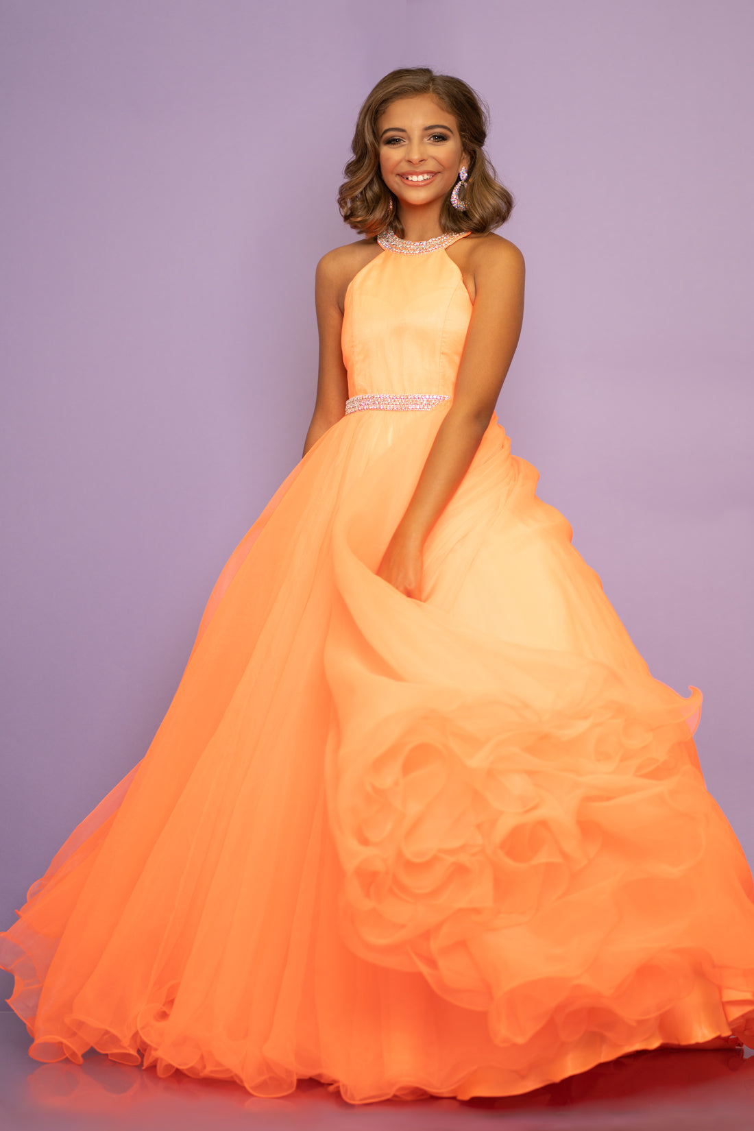 Sugar Kayne C114 by Johnathan Kayne is an Organza Girls Ball Gown Pageant Dress. Featuring a high neckline with crystal rhinestone accents. The waist line is broken with a crystal bling belt. The lush Ball gown skirt features a horse hair trim. Glide across the stage in the classic beauty!

Available Colors: Aqua, Barbie Pink, Jade, Lilac, Neon Orange, Royal, Ruby Red, White, Yellow
Available Size: 2-16

(Sizes 2-6 do not have bust cups, Sizes 8-16 will have preteen size bust cups)