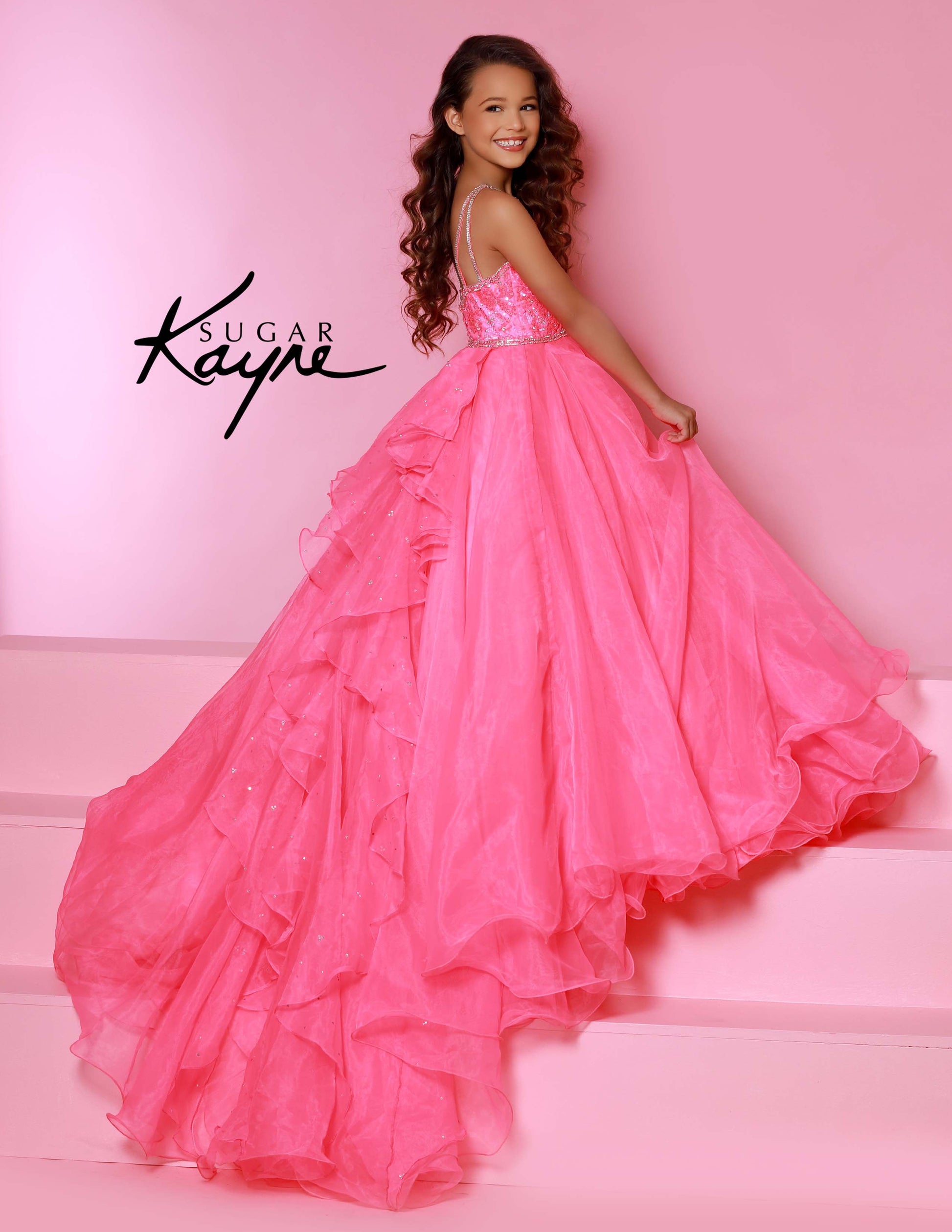 Sugar Kayne C143 Girls and Preteens Pageant Dress.&nbsp; This is a beautiful flowy organza pageant gown with embellished high neckline.&nbsp; This dress features an organza ruffle that flows down the back of the dress.

Colors: &nbsp;Hot Pink, Magenta, Red, Royal, White, Yellow

Sizes:&nbsp; 2-16

(Sizes 2-6 do not have bust cups, Sizes 8-16 will have preteen size bust cups)

Fabric:&nbsp; Satin, Organza, Stretch Lace
