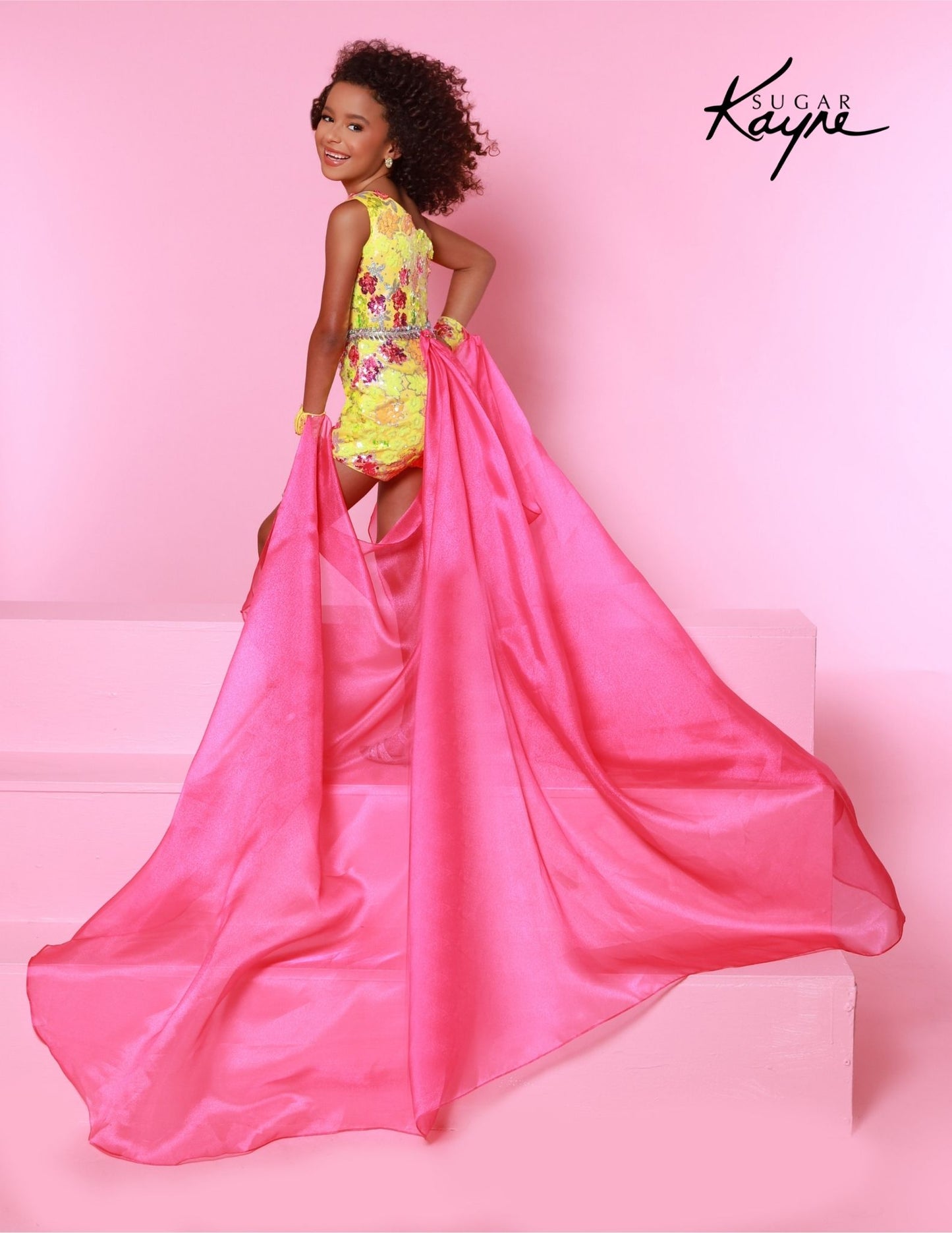 The Sugar Kayne C347 is a fun, fashion shimmer girls pageant romper with a sequins mesh overskirt. It's designed with soft and comfortable material, perfect for any special occasion.&nbsp;Shine bright on stage with our Sequin Mesh Romper and Shimmer Organza Overskirt! This romper is designed for those girls who love to sparkle and own the stage!

Color:&nbsp;Bluetiful, Lemon Burst

Size:&nbsp;2, 4, 6, 8, 10, 12, 14, 16

Fabric:&nbsp;Sequin Stretch Mesh, Metallic Jersey Lining, Shimmer Organza

(Sizes 2-6 do