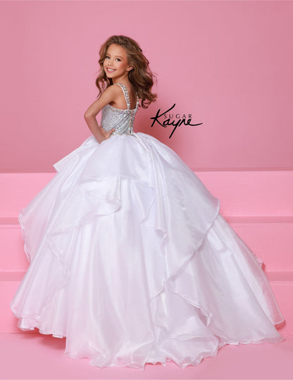 Step onto the pageant stage with confidence in the Sugar Kayne C383 Girls Pageant Dress. This stunning ballgown features a crystal bodice that will shimmer and shine under the lights, while the ruffle detail adds a touch of playful elegance. The layered skirt adds volume and movement, making you the star of the show. Make a dramatic statement at your next pageant with this stunning diamond mesh dress. The ruffled shimmer organza skirt completes the look, offering a perfect blend of elegance and flair.

Size
