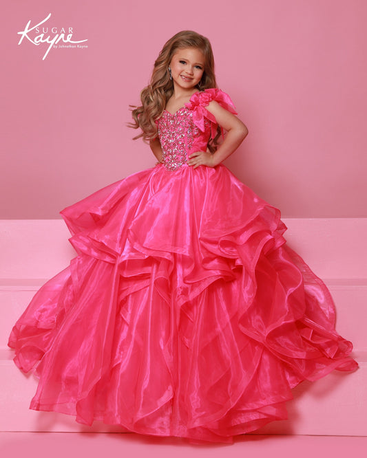 Designer: Sugar Kayne — Style C398
Sugar Kayne style C398 is a classic girls pageant dress with layered organza and a smooth satin lining for beautiful volume and shine. The full skirt and refined bodice give this gown timeless pageant appeal, making it ideal for everything from local titles to national stages.

Sizes: 2–16
Colors: Barbie Pink, Tangerine, Turquoise, White