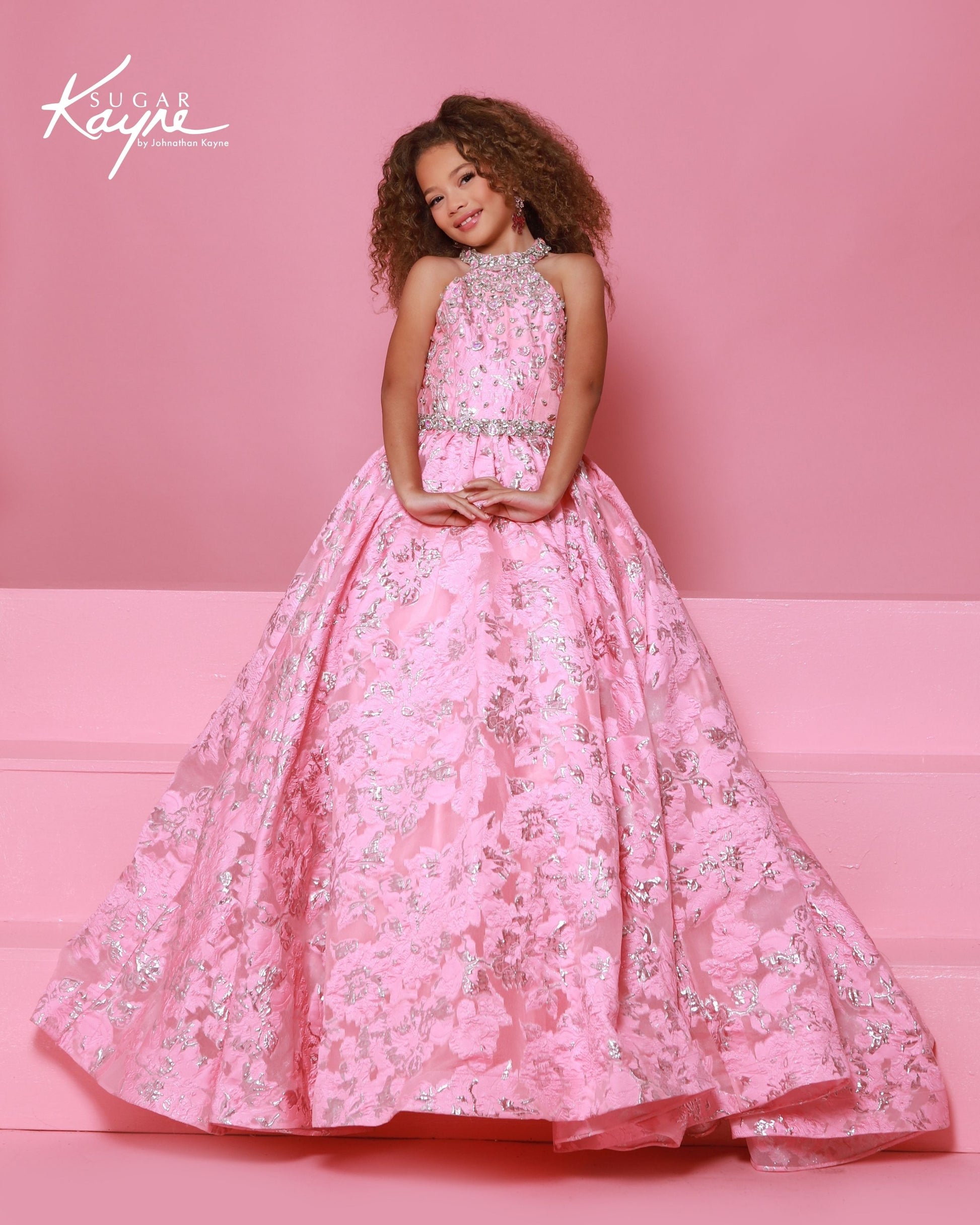 Designer: Sugar Kayne — Style C404
Sugar Kayne style C404 is a classic girls pageant dress with layered organza and a smooth satin lining for beautiful volume and shine. The full skirt and refined bodice give this gown timeless pageant appeal, making it ideal for everything from local titles to national stages.

Sizes: 2–16
Colors: Metallic Blue, Metallic Pink